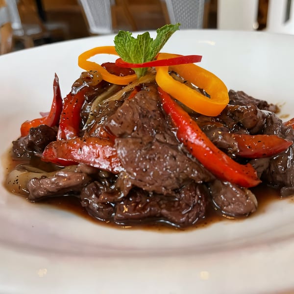 Colonial Kitchen and Bar's Thai beef dish with red and yellow bell peppers, onions, and mint.